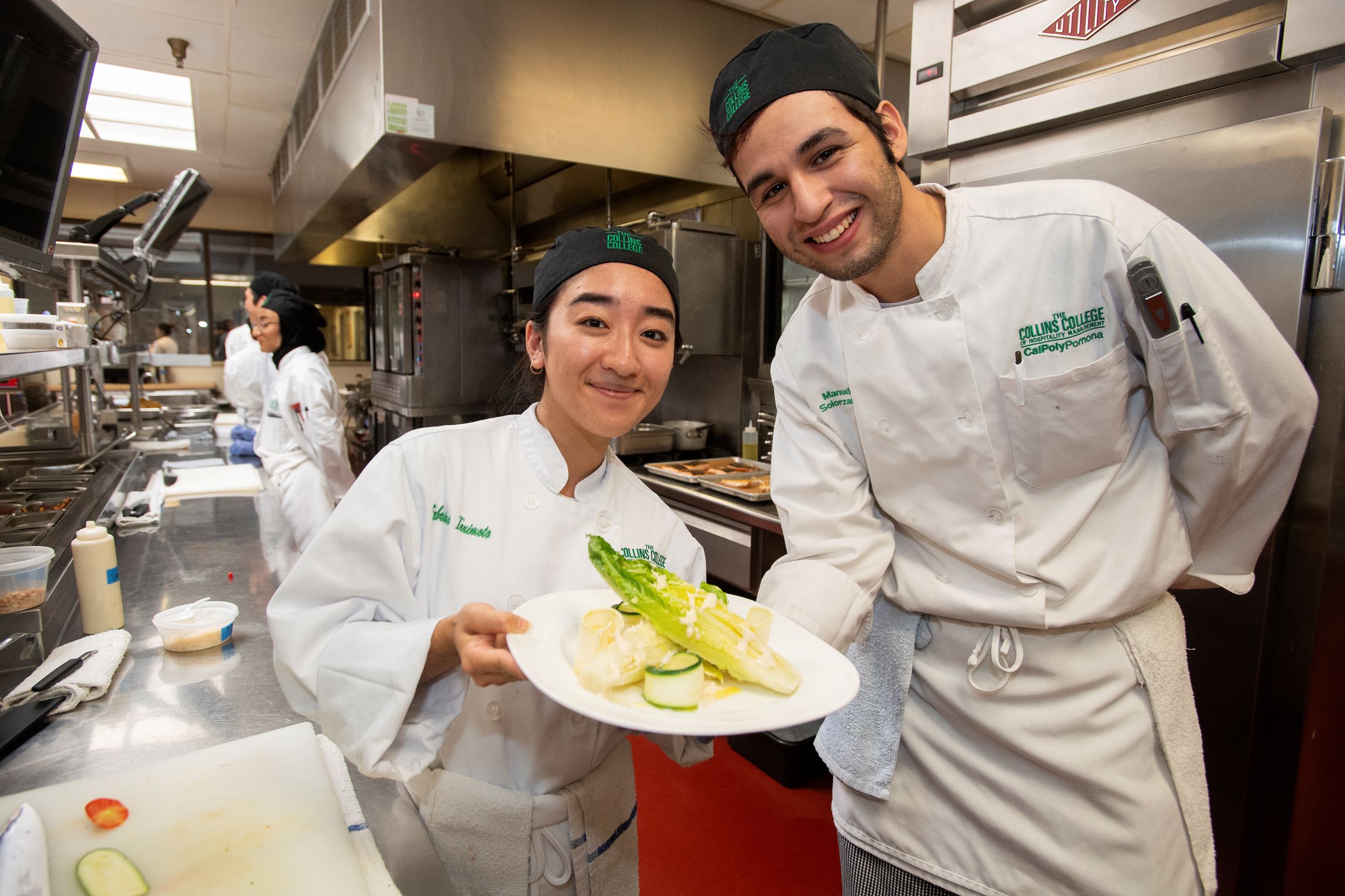 Two students show a plated meal at the RKR