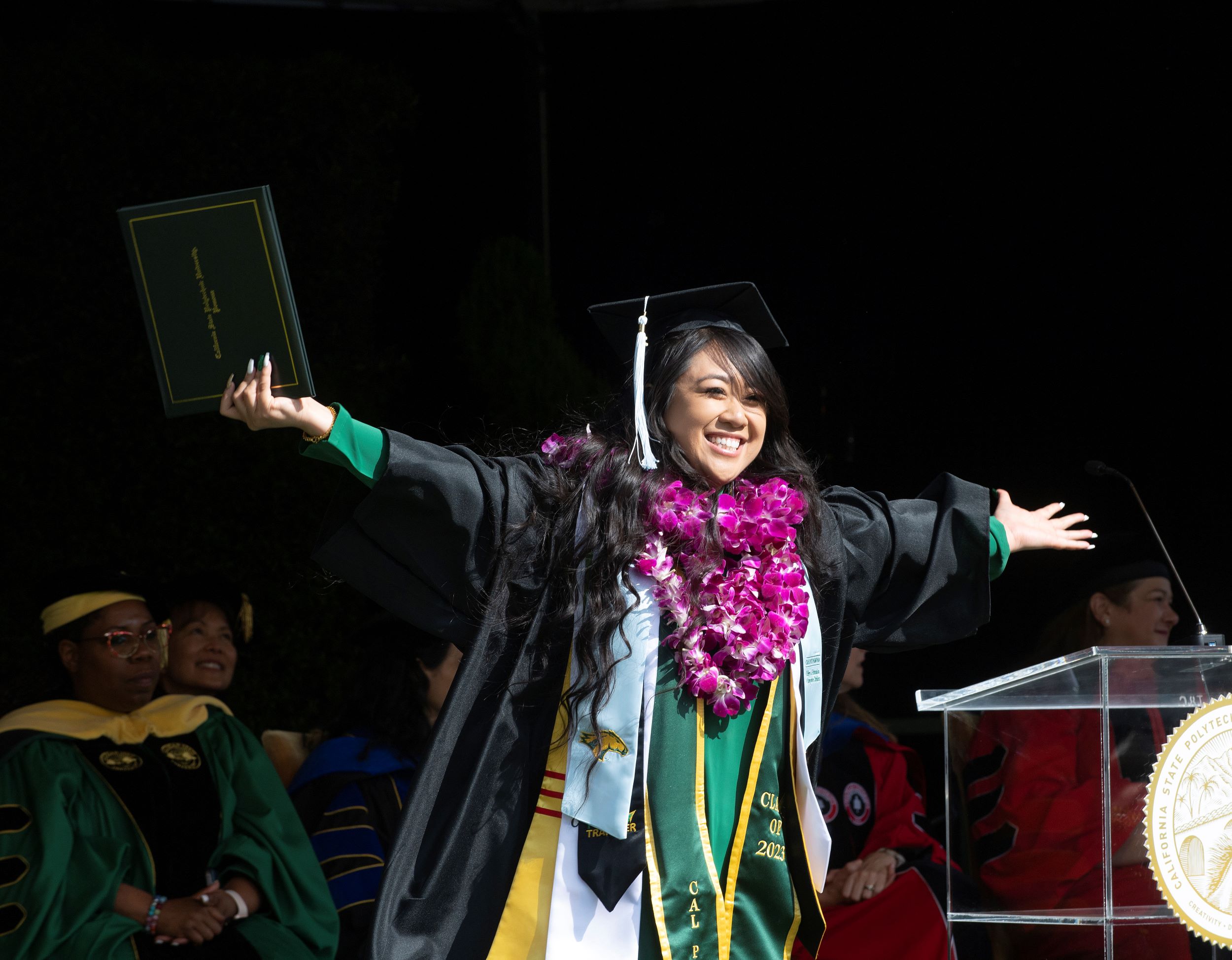 A female graduate celebrates at the commencement stage