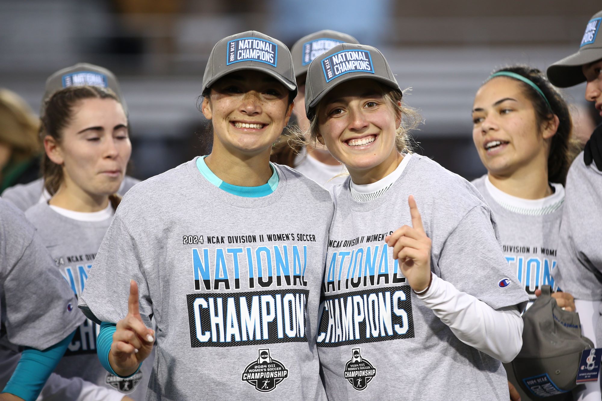 Women's Soccer Champions holding up number 1 finger