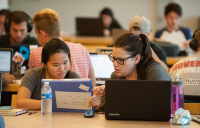 Two female students studying in the Library with their laptops