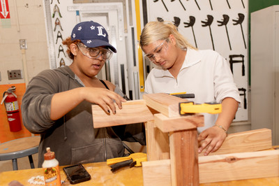 Two female students working at a wood shop