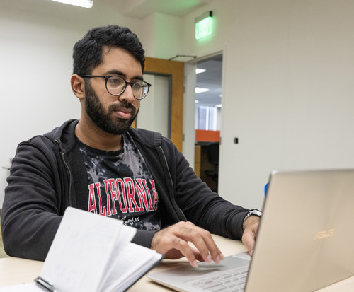 Student in dorm looking at laptop