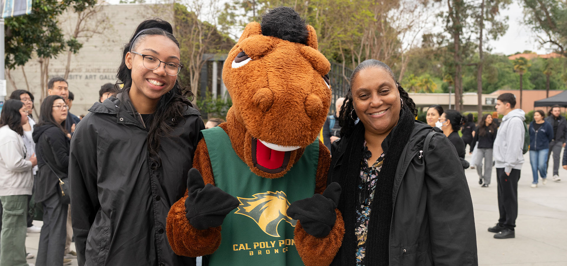 Two women pose for a photo with Billy Bronco