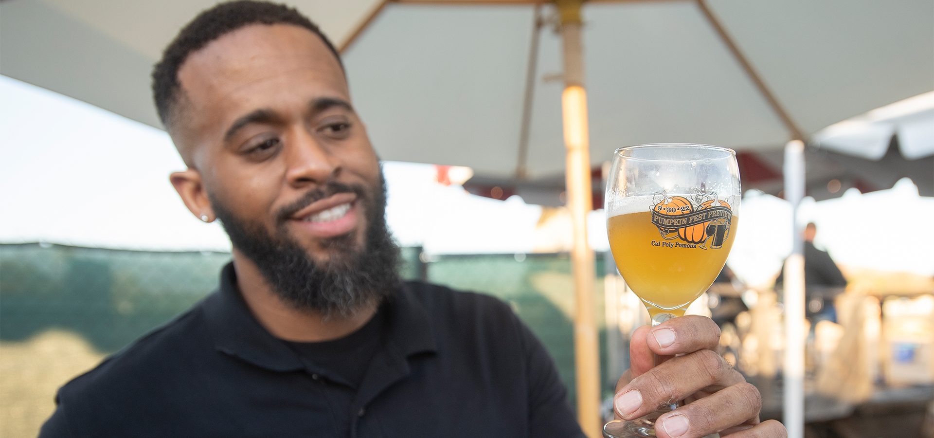 A man holds up a glass of beer