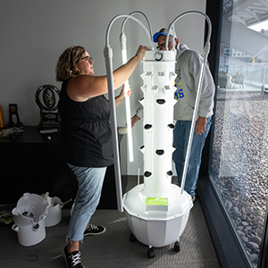 A woman sets up the grow tower/vertical garden.