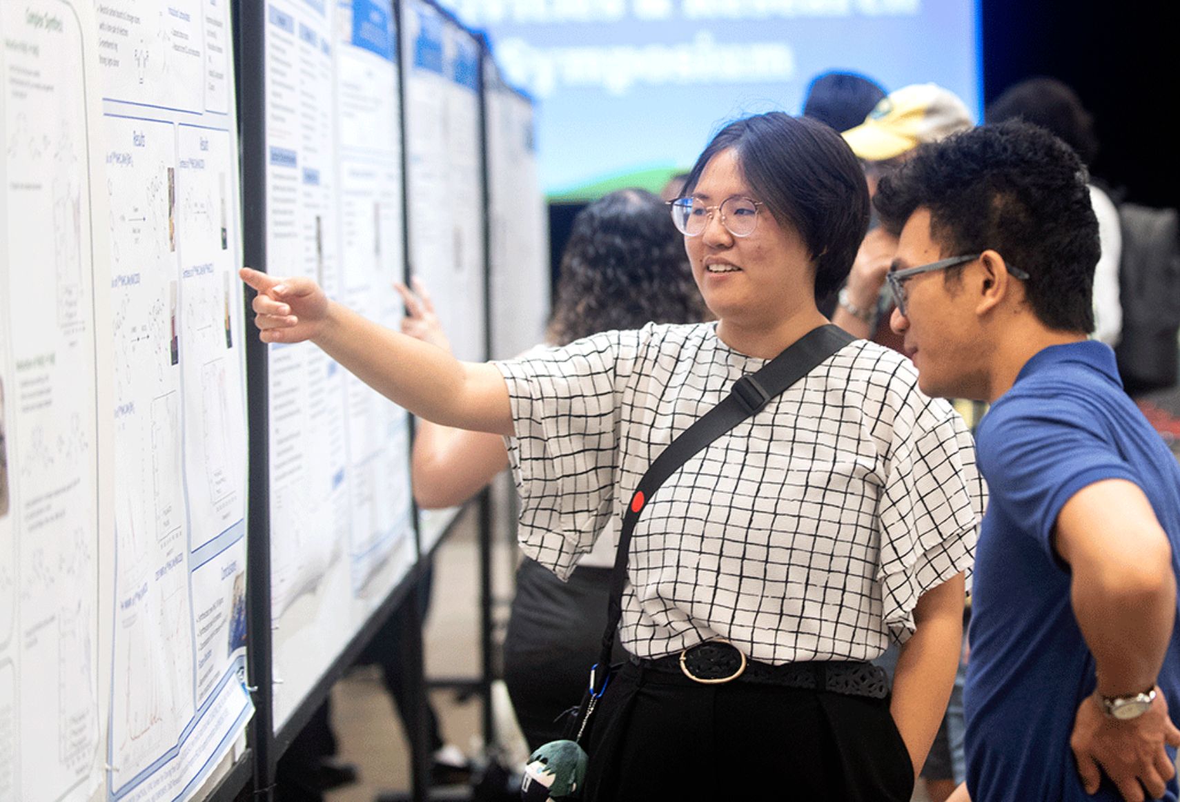 Two students look at a research poster.