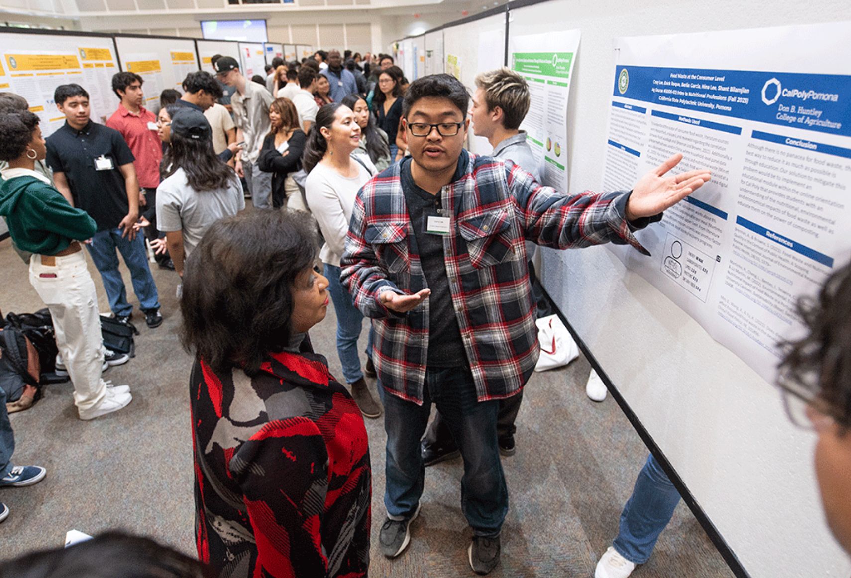 President Coley listens to a student present their research poster.