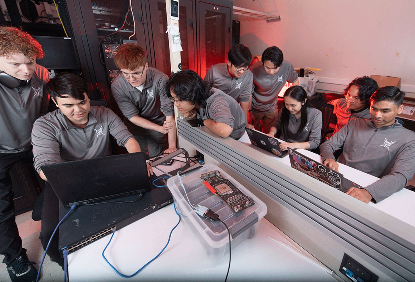 group of students surrounding a laptop