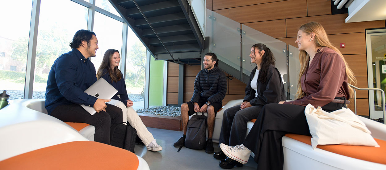 Students sitting and talking in lobby of College of Business Administration