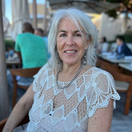 professor blakistone wearing a white outfit sitting outside