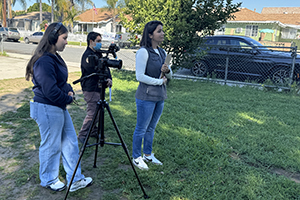 Students filming in a neighborhood