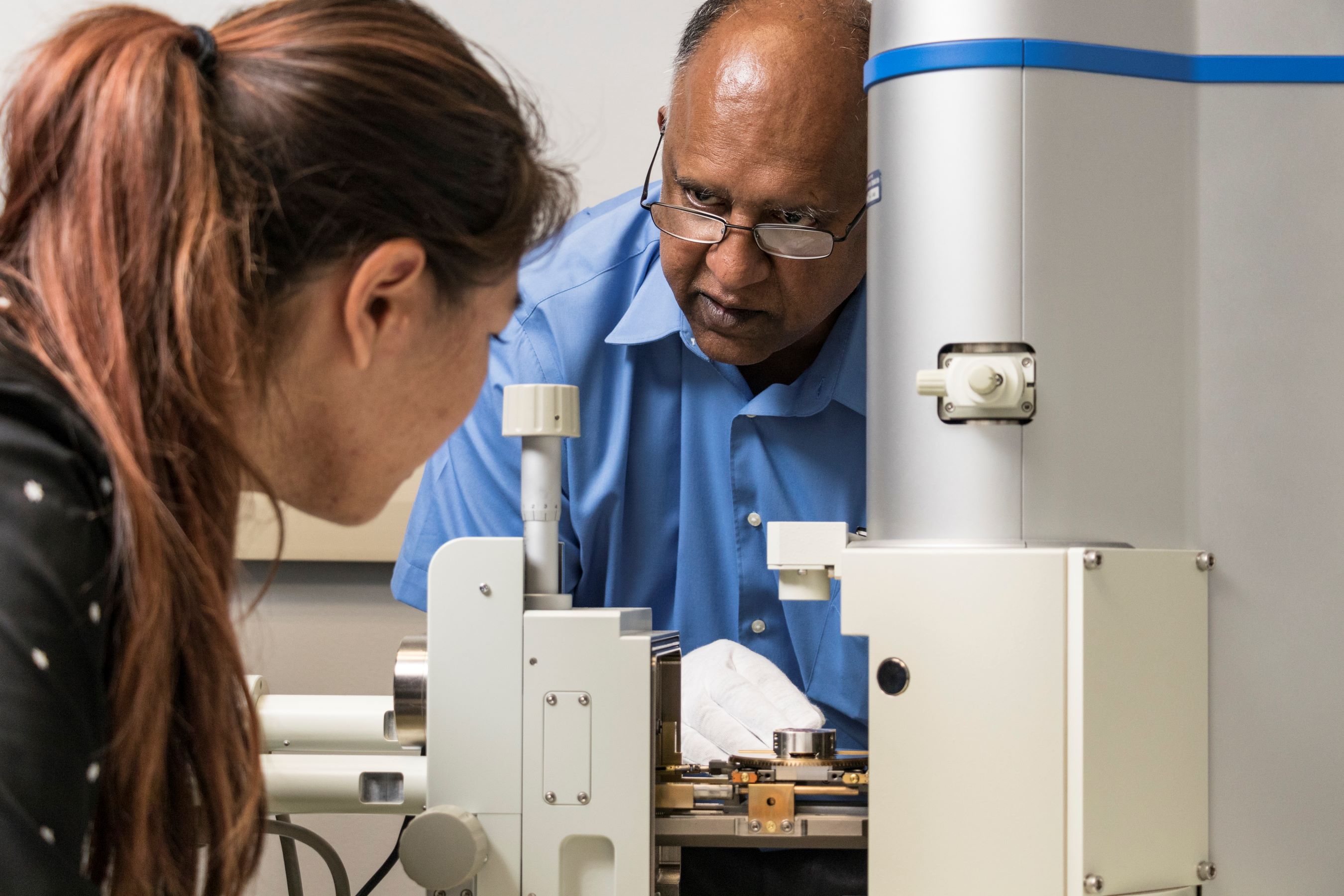 Vilupanur Ravi teaching a student how to use a scanning electron microscope.