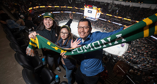 Three alums hold a Cal Poly Pomona scarf at the 2023 CPP Night at Ducks.