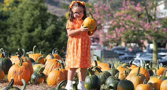 Talia holds a pumpkin during the 2023 Pumpkin Fest.