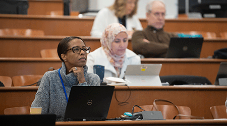 Female faculty members sit and listen during the 2023 winter institutes