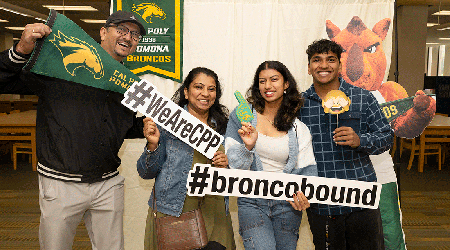 A family celebrates wit #WEARECPP and #broncobound signage.