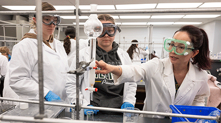 Three female students work on a project in the organic chemistry lab.