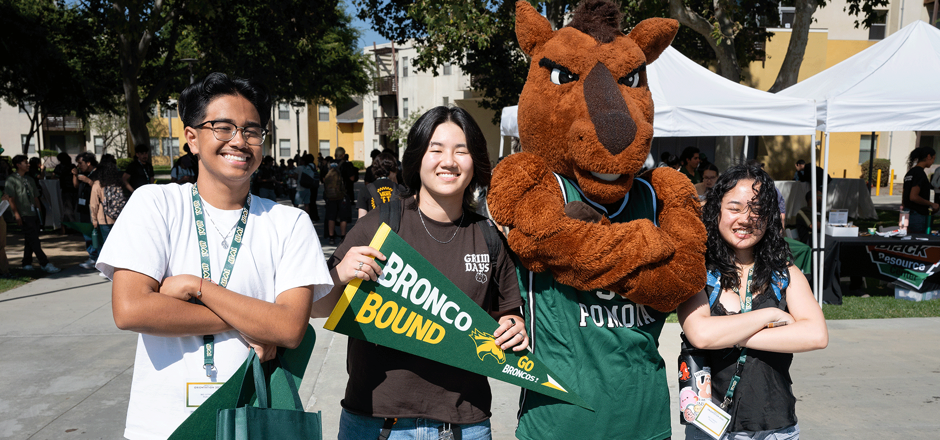 Three students pose with Billy Bronco