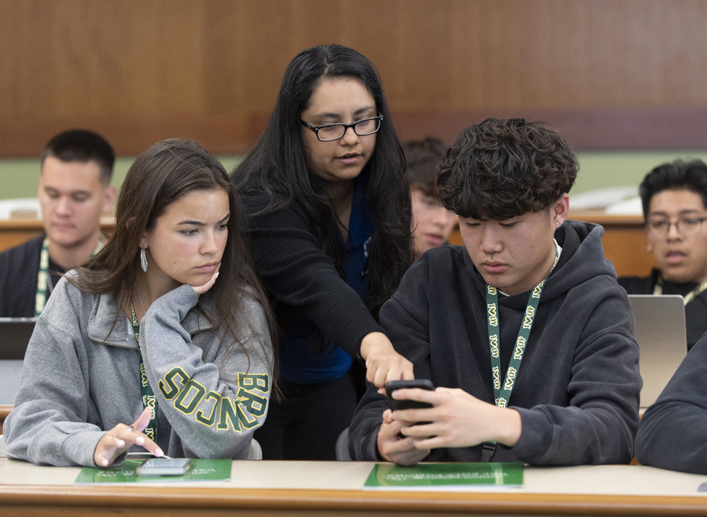 Faculty assisting two students during orientation