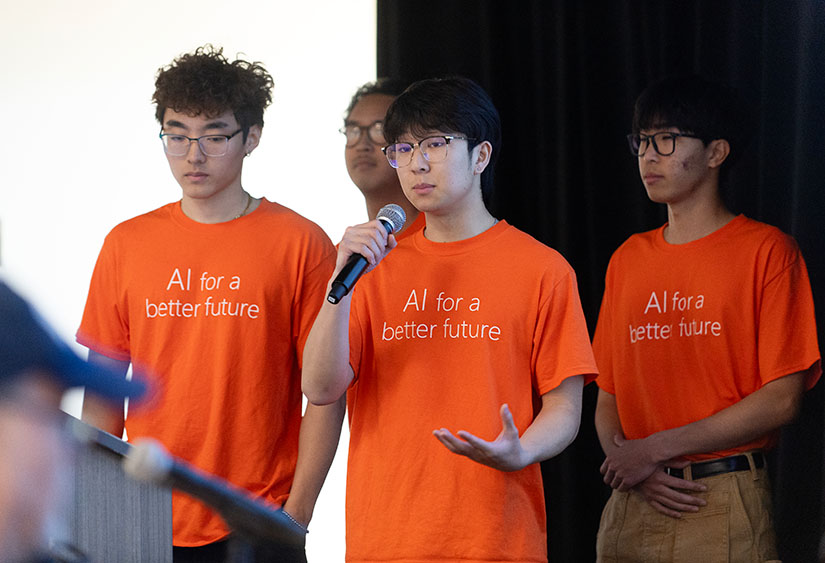 four male students present on stage