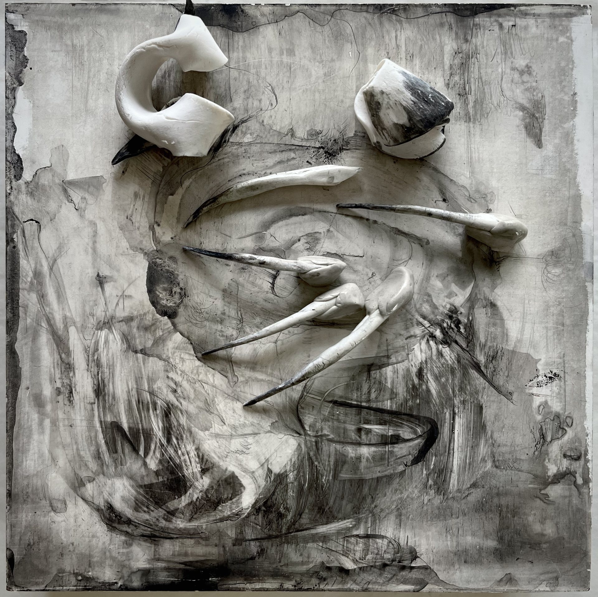 A grayscale abstract composition with swirling, smudged patterns, accented by smooth, curved, bone-like objects attached to the surface, creating a three-dimensional effect.