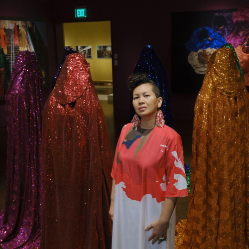 Artist Anida Yoeu Ali standing next to her "Rainbow Brigade"