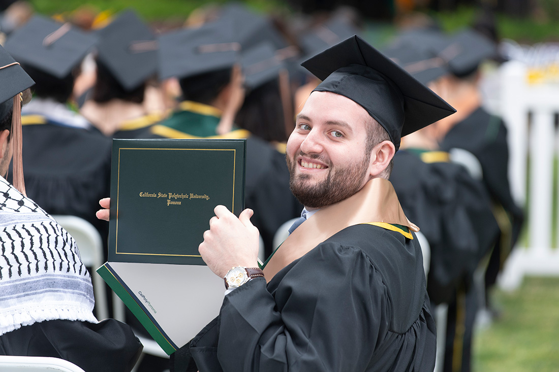 Male graduate gives a thumbs up