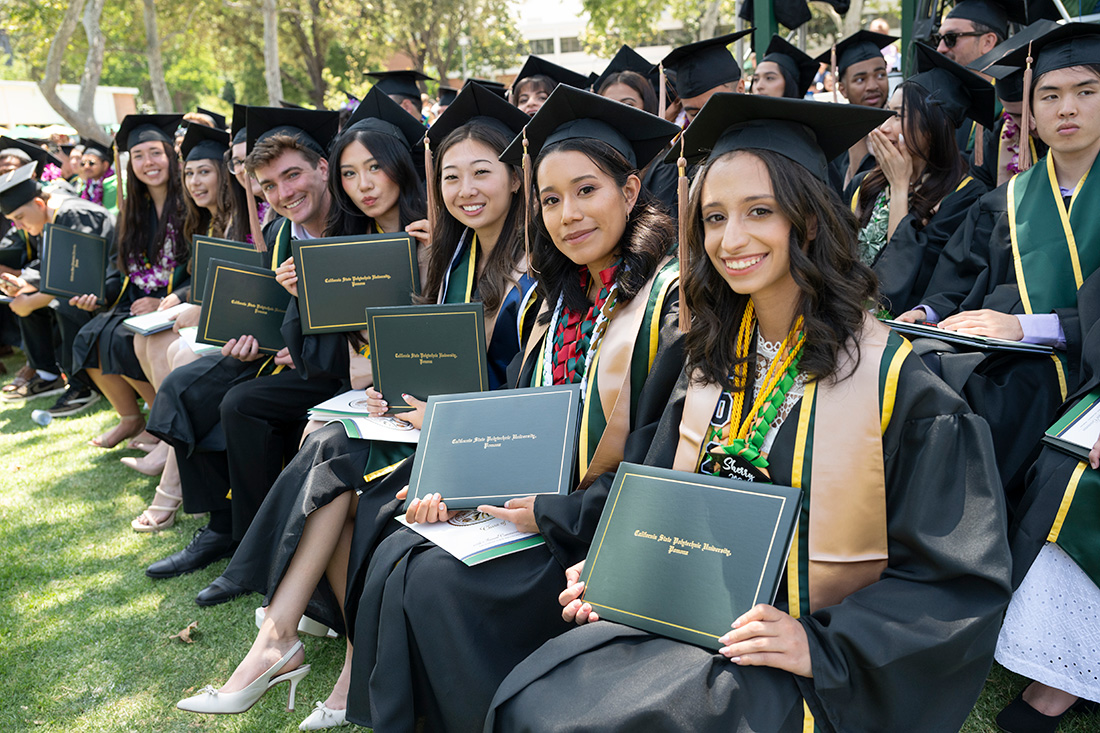 Group of students from the college of business smile during the commencement ceremonies.