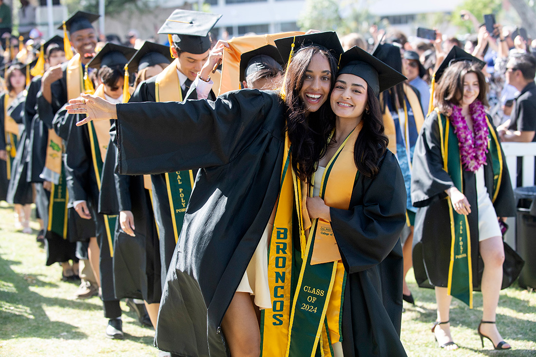 Two female graduates pose for a photo
