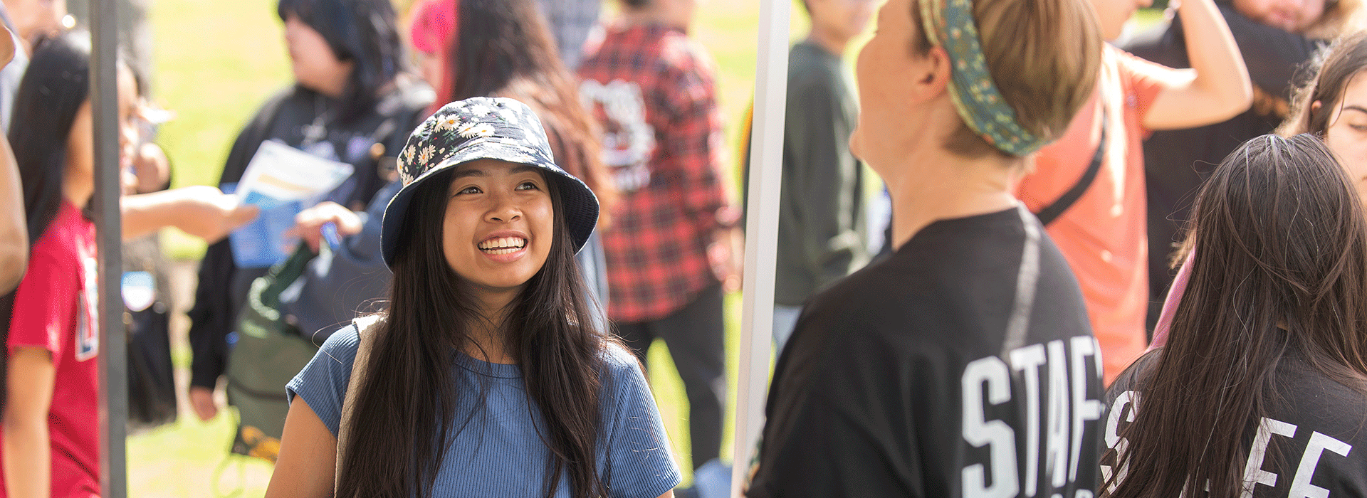 Female prospective student smiles during open house activities. 