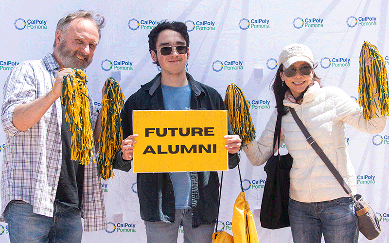 New student holding future alumni welcome sign 