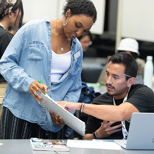 A counselor works with a student at a desk.