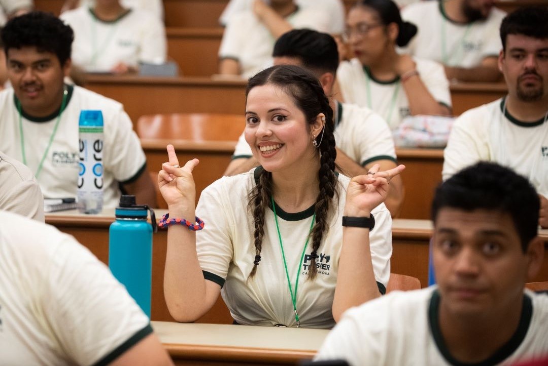 Student in a PolyTransfer t-shirt holds up peace signs