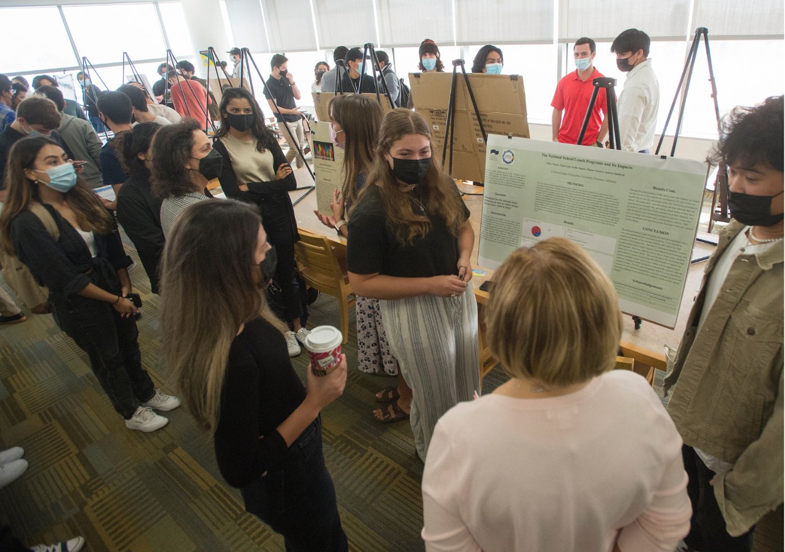 Picture of student attendees and presenters participating in the PolyX Showcase event, following COVID-19 social distancing and masking protocols.