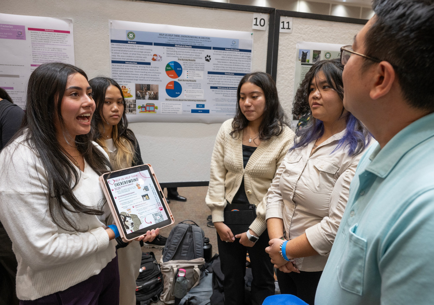 Group of students explaining their research project(s) to audience members during the PolyX Showcase.
