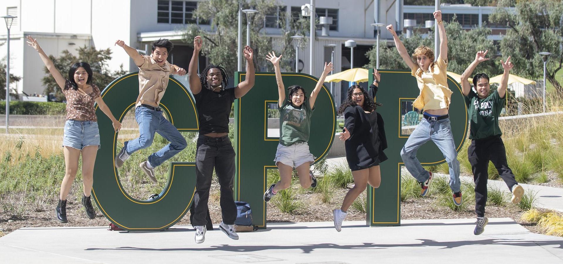 students jumping in front of the CPP letters