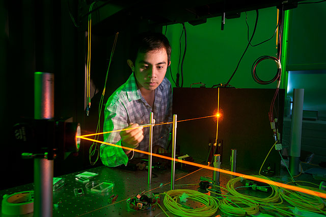 Photo of a student working with a laser apparatus