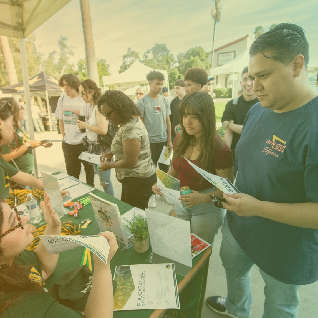 Students stop and ask questions at a tabling event