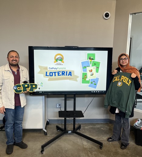 Loteria winners pose next to screen with Project Caminos logo and Loteria cards.