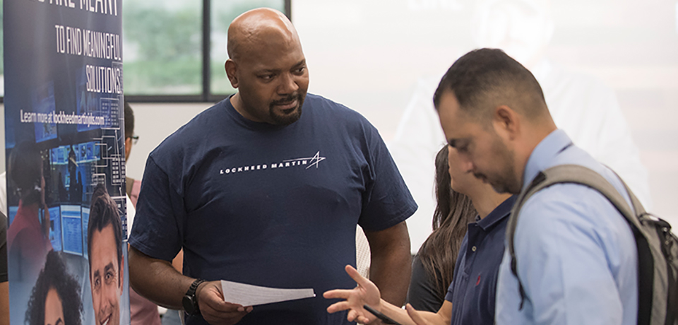 Lockheed Martin representative networking with student at Future Forward.